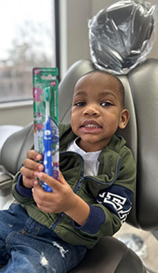 A kid with a tooth brush at Arsmiles Family & Cosmetic Dentistry, OH
