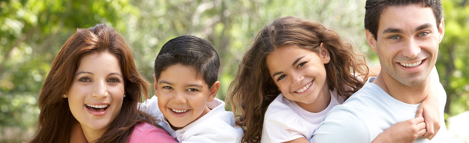A happy family smiling together, representing preventative dental care for all ages.