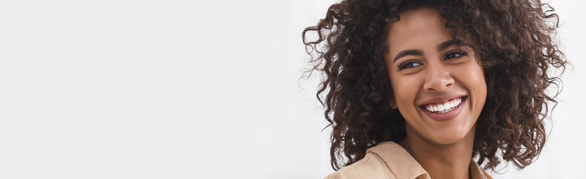 A beautiful woman with a bright smile, symbolizing the benefits of cosmetic dentistry.