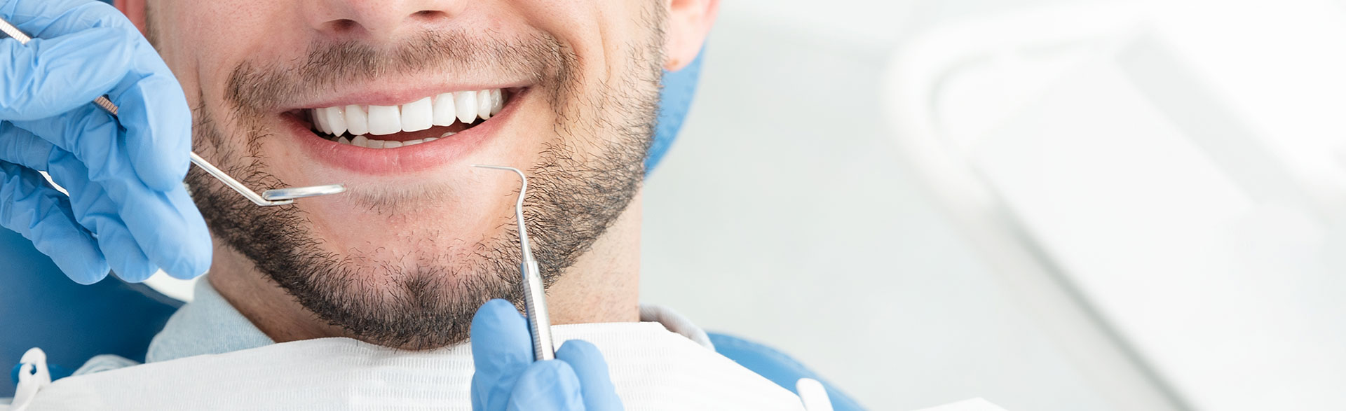 A man smiling during the surgical stage of a dental implant procedure.