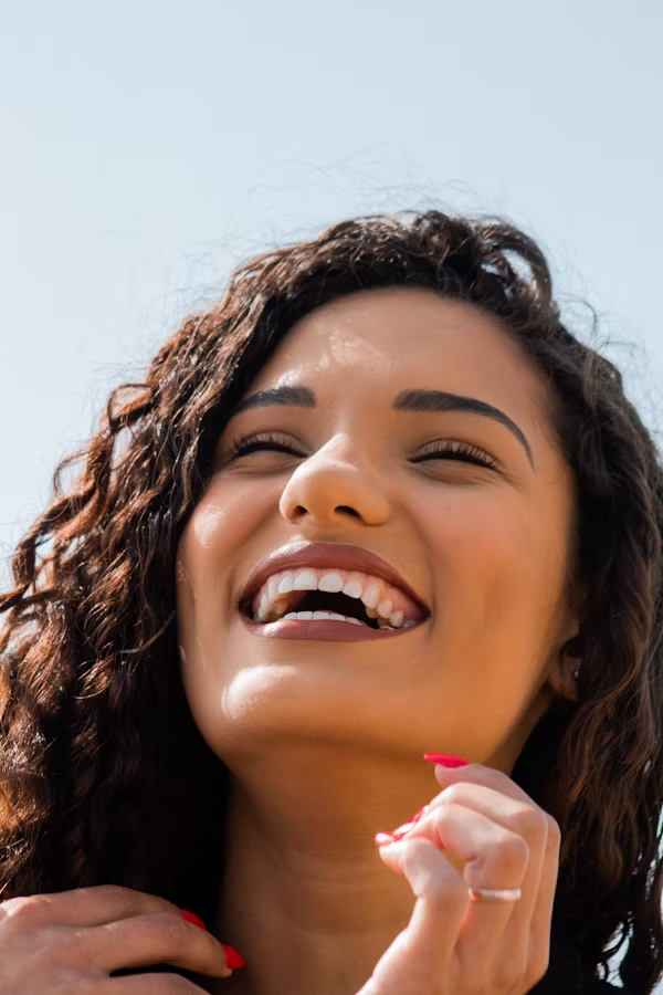 photo of a woman with curly hair smiling widely