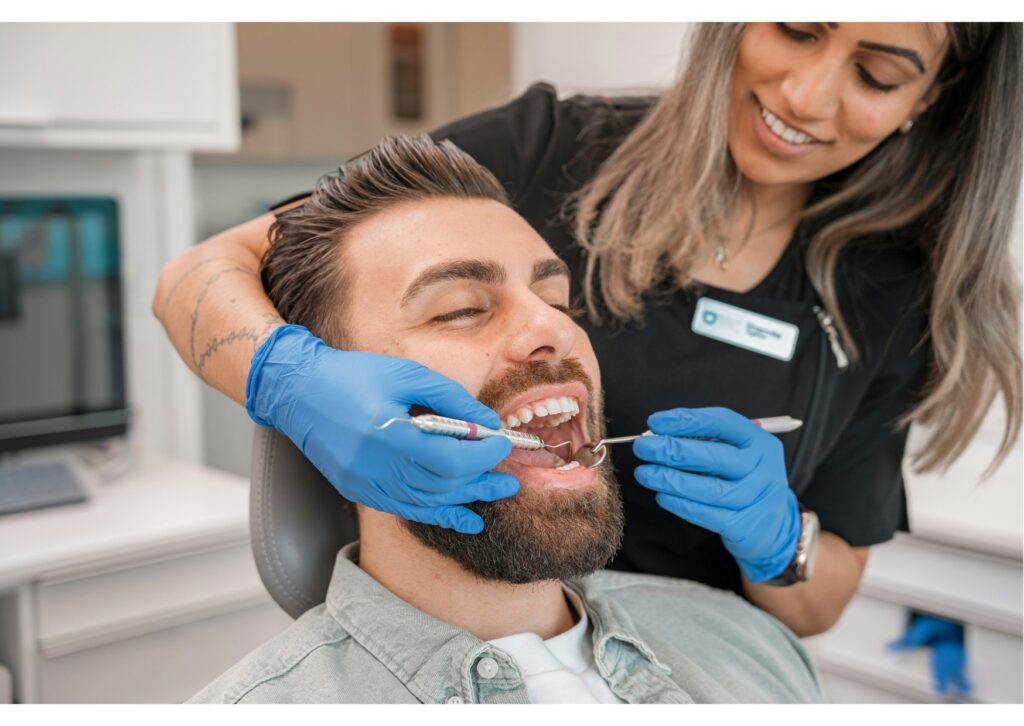 Dentist examining patient to assess suitability for bonding vs. veneers treatment.