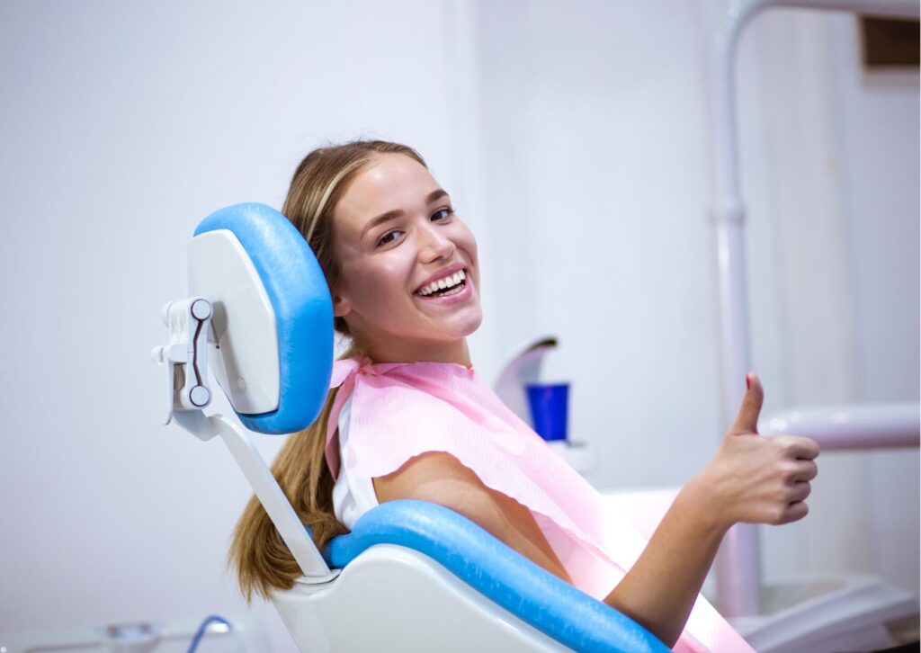 Smiling patient in a dental chair after evaluation for a cracked tooth, highlighting the importance of diagnosis and treatment for cracked tooth symptoms.