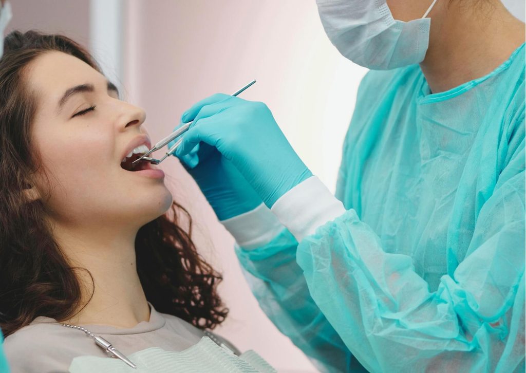 Patient receiving a cosmetic dental bonding procedure during a dental visit to restore and improve the appearance of a tooth.