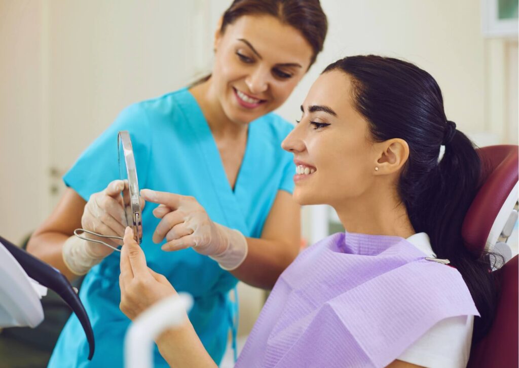 Patient reviewing her smile with a dentist after gum contouring treatment to evaluate the appearance of the reshaped gumline.