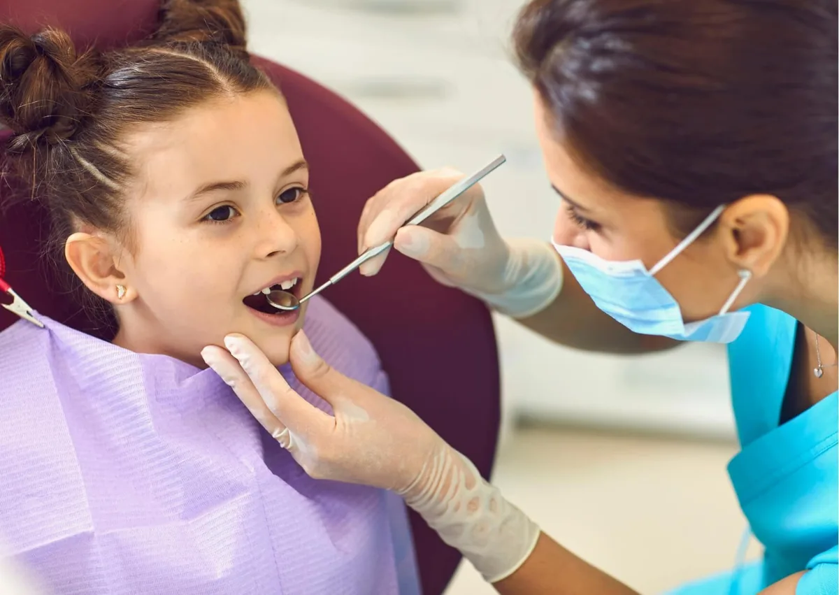 Pediatric dentist examining a child’s teeth to determine whether a dental spacer is needed.