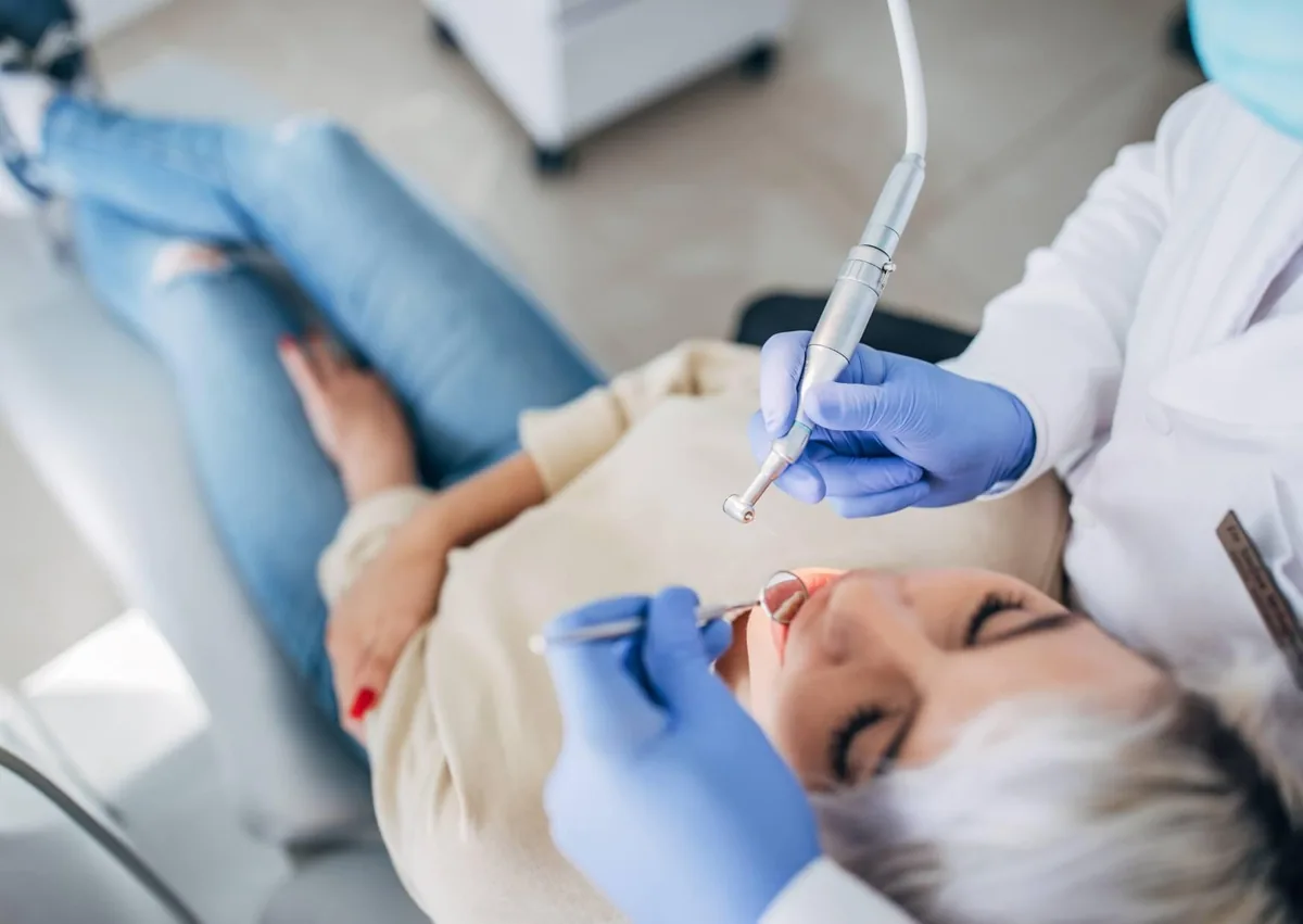 Dentist performing a cosmetic dental procedure on a patient, highlighting treatments that influence cosmetic dentistry costs.